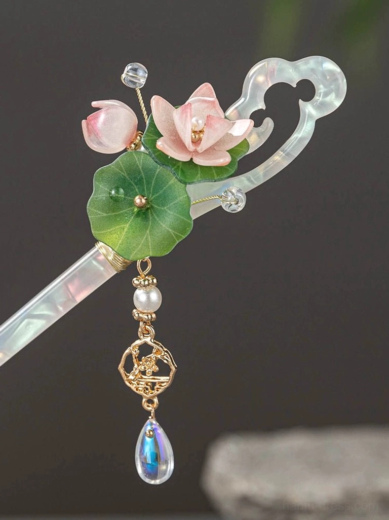 Full overhead view of a glazed lotus Chinese hair stick with iridescent shaft, pink lotus blossoms, green leaves, crystal details, and decorative pendant