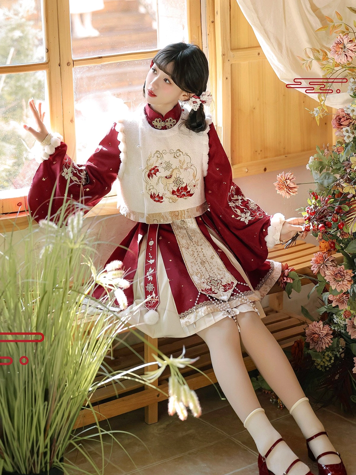 Seated side view of Gallop in Spring Chinese New Year Hanfu dress with layered Ming style silhouette, embroidery and matching red handbag