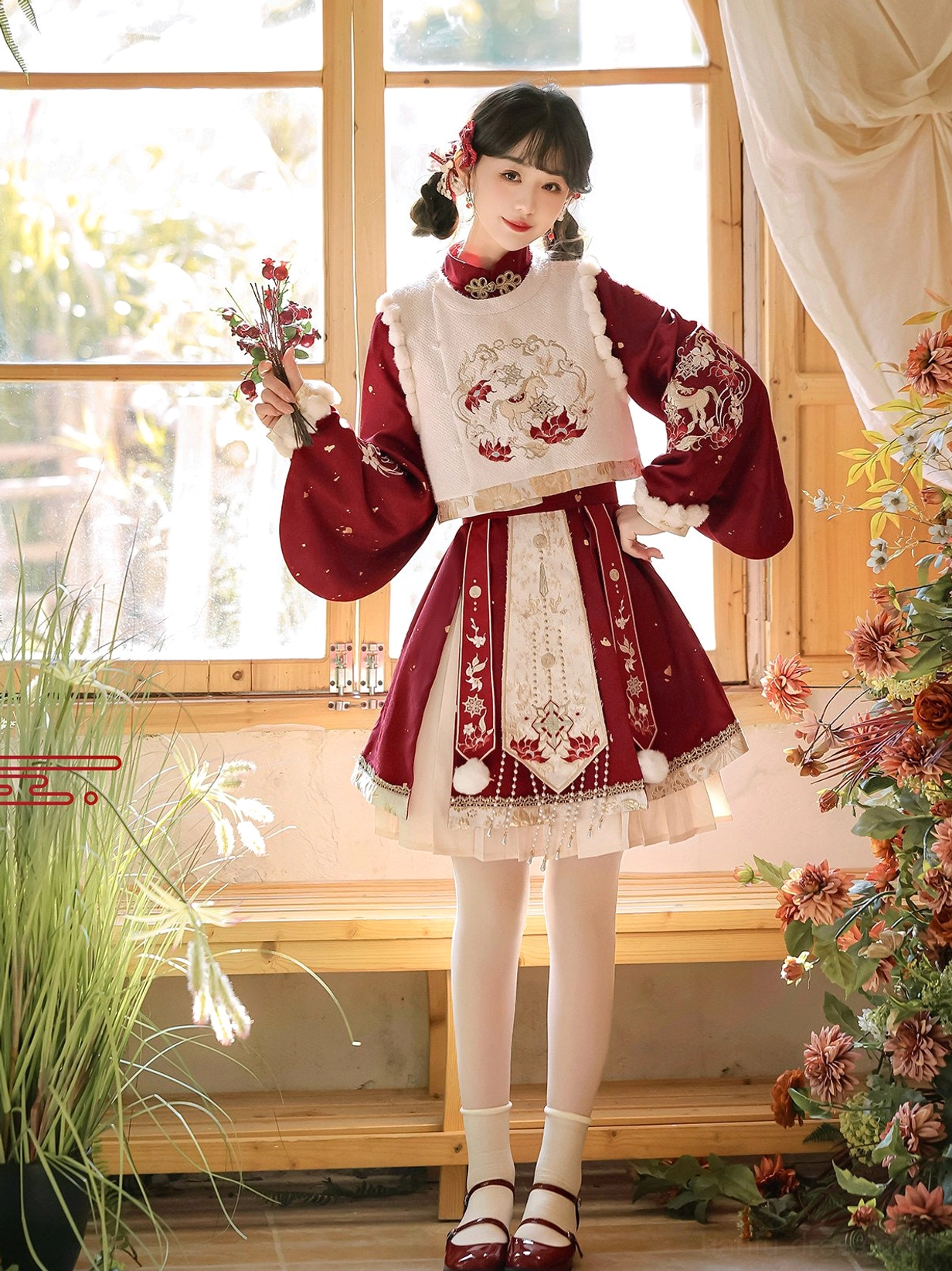 Front standing view of festive Ming style Hanfu Chinese New Year dress featuring wine red sleeves, ivory pleated skirt and traditional embroidery