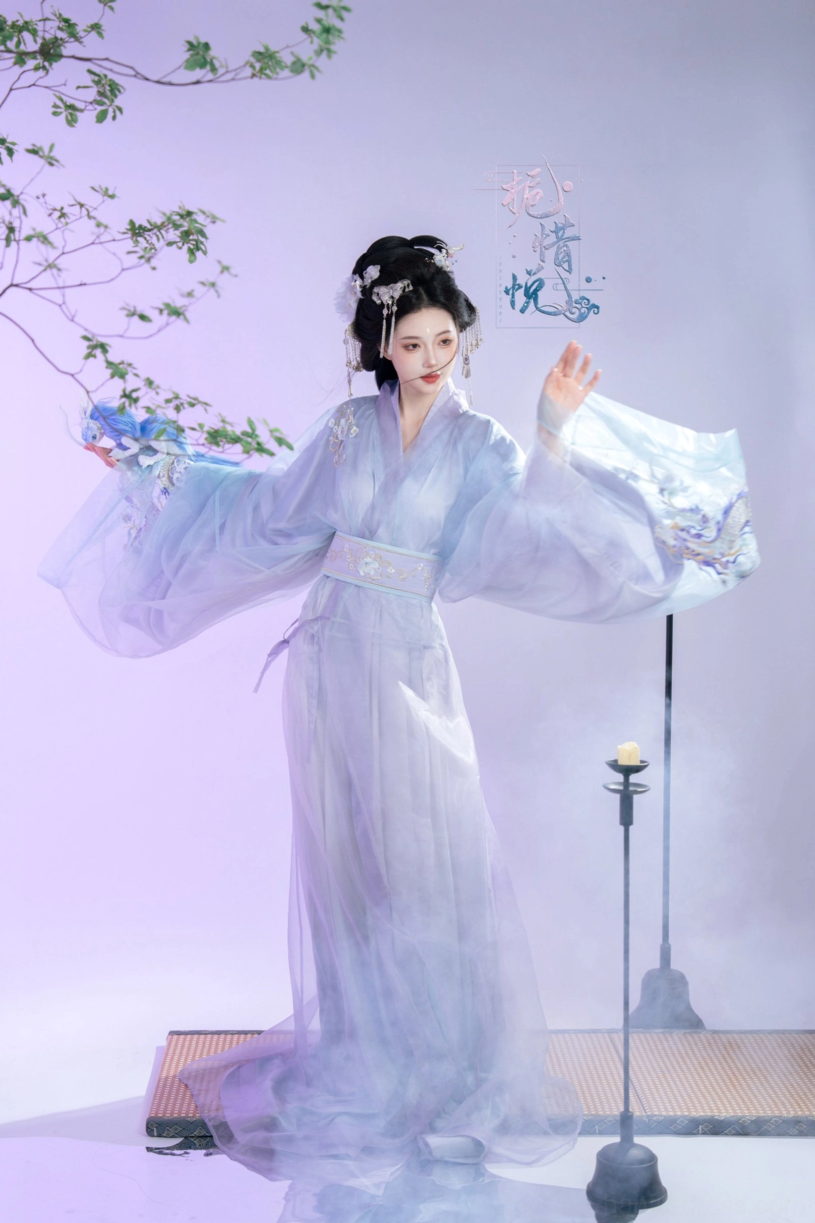 Gardenia Chinese Hanfu robe in a left three quarter pose featuring cross collar construction, tied waist sash, sleeve embroidery, and sheer layered skirt