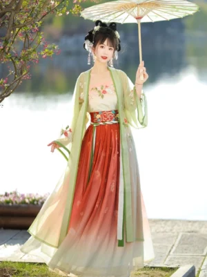 Full-body front view of Gardenia Song Dynasty Qiyao Ruqun Hanfu with sheer green embroidered beizi coat, floral camisole, gradient terracotta and ivory skirt, peony waist sash, and traditional Chinese styling beside a lakeside garden
