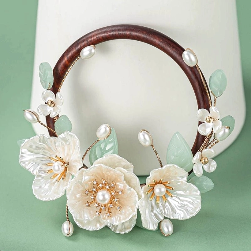 Close-up of gardenia inspired Chinese hairpin ornament featuring shell-style flowers pearl beads pale green leaves and delicate hanging pearls