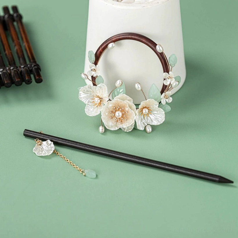 Gardenia wood Chinese back hairpin with dark wooden hair stick floral ring ornament pearl beads green leaf details and tassel charm flat lay