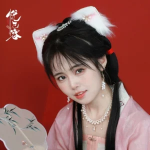 Girl wearing a jade pearl Chinese hair pin with pink Hanfu, pearl jewelry, fluffy cat ear hair clips, and a Chinese hand fan against a crimson red background