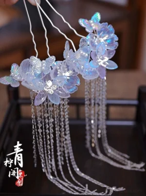Glazed blue purple flower tassel hair pins for Hanfu displayed on a dark Chinese style wooden tray with silver crystal tassels and butterfly details