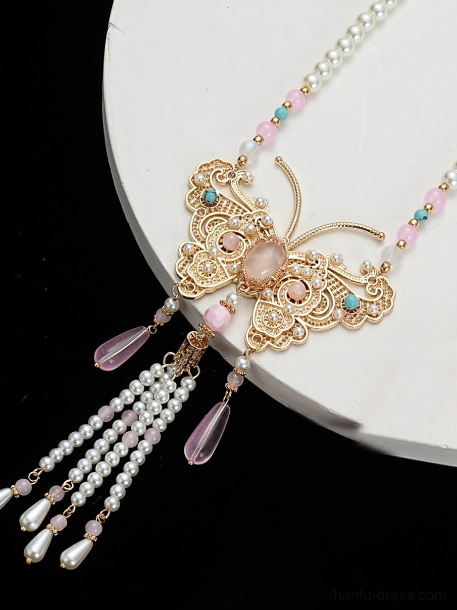 Close-up side view of gold filigree butterfly Chinese necklace with pink and turquoise accent beads pearl chain crystal drops and tassel details