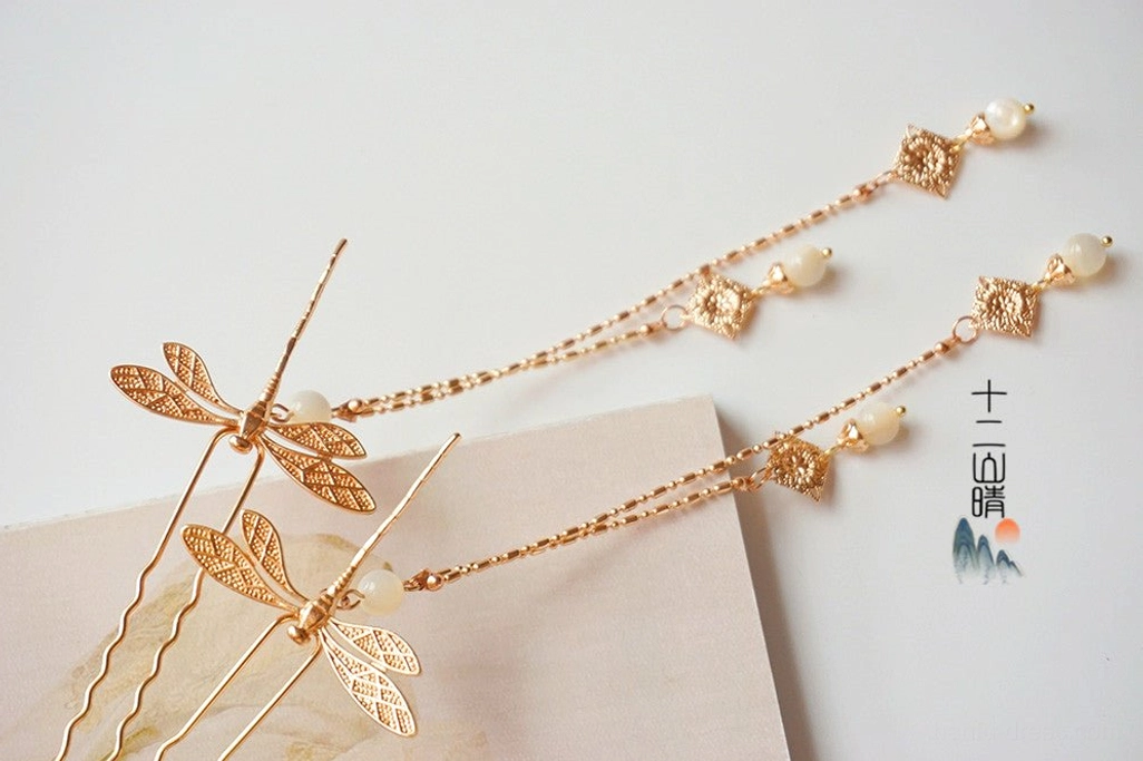 Gold Chinese dragonfly tassel hair pins pair with white pearl style beads ornate drop pendants and long chain tassels on beige display paper