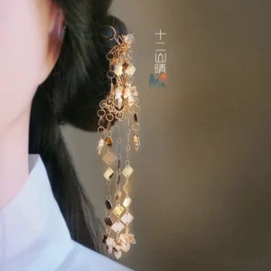 Gold floral tassel hair pin worn in a traditional Chinese Hanfu updo, featuring crystal accents, diamond pendants, and flowing chain tassels