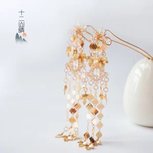 Pair of gold floral tassel hair pins for Hanfu and Qipao displayed on a white background with openwork flowers and crystal tassels