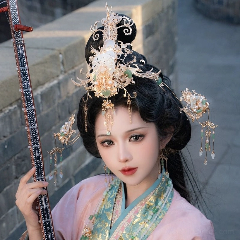 Traditional Chinese hanfu hair accessory set with gold crown white jade-inspired details and tassel ornaments worn with pink hanfu and a Chinese pipa
