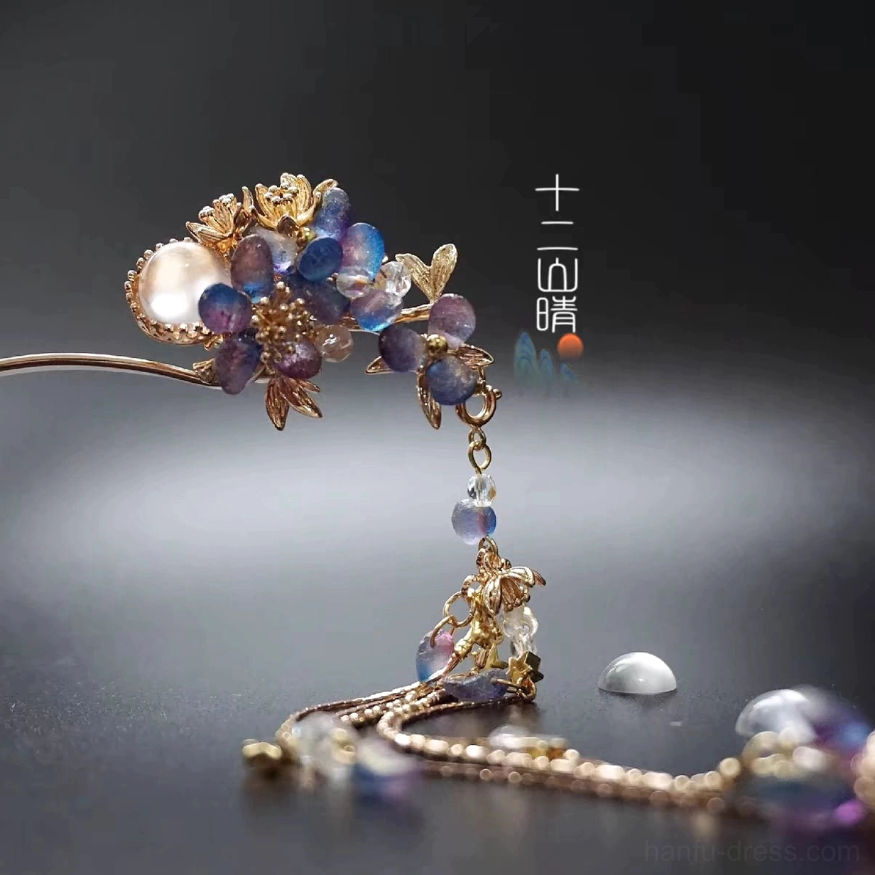 Close-up of gold tone floral Hanfu hairpin with blue purple beads white pearl-like center and dangling tassel
