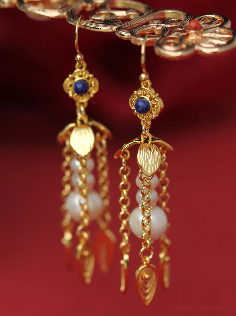 Gold-tone Hanfu pearl tassel earrings hanging on a jewelry display bar, featuring layered chains, blue beads, and leaf-shaped pendants