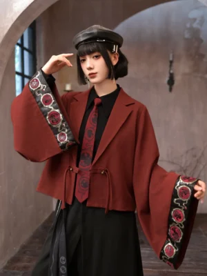 Burgundy Golden Crow modern Hanfu cropped blazer shown from a three-quarter front view with wide embroidered sleeves, dragon-inspired cuff motifs, notched lapel, and front drawstring closure