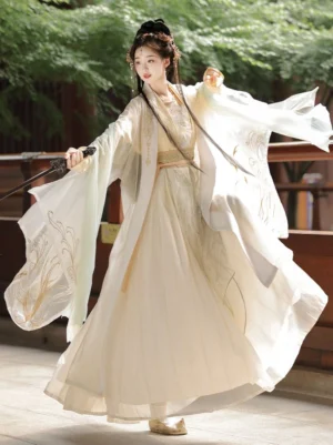Full body side view of a woman wearing cream beige Golden Glow Song Dynasty Qiyao Ruqun Hanfu with flowing wide sleeves, golden feather embroidery, wrap skirt, and matching waist sash in an ancient Chinese courtyard