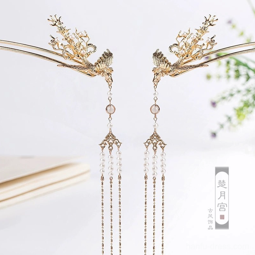 Pair of golden phoenix tassel hairpins with carved floral details pearl-like chains and decorative beads displayed on a light background