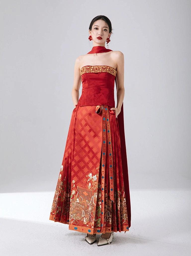 Front full body view of Golden Treasure red Chinese New Year bustier styled with a festive mamian skirt, gold trim, and traditional auspicious floral skirt pattern