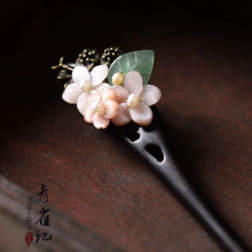 Good Year floral Chinese hair stick close-up with pink white shell flowers green leaf antique bronze filigree and dark carved wooden pin