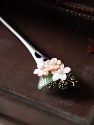 Side view of Good Year Hanfu flower hair stick showing pink white floral decoration bronze details and pointed dark wooden stick