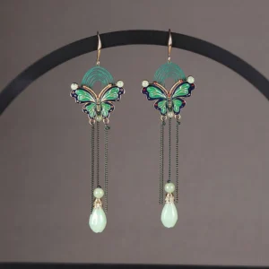 Matching Chinese butterfly teardrop earrings with enamel wings black tassel chains and jade style pendants shown on a jewelry display rack
