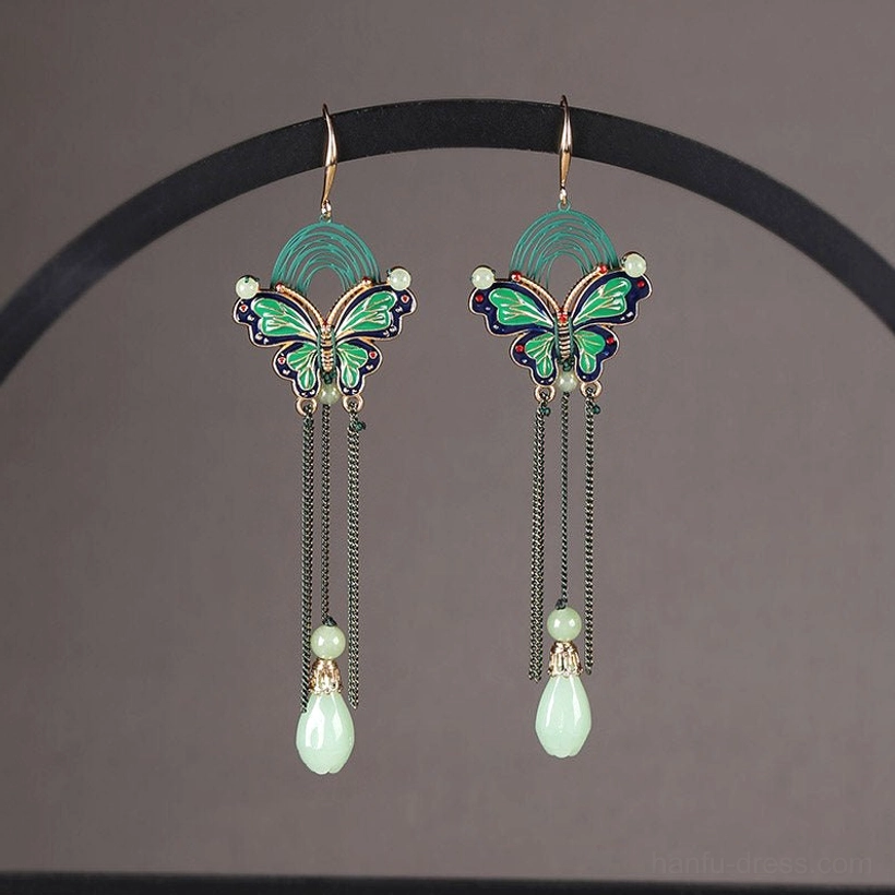 Matching Chinese butterfly teardrop earrings with enamel wings black tassel chains and jade style pendants shown on a jewelry display rack