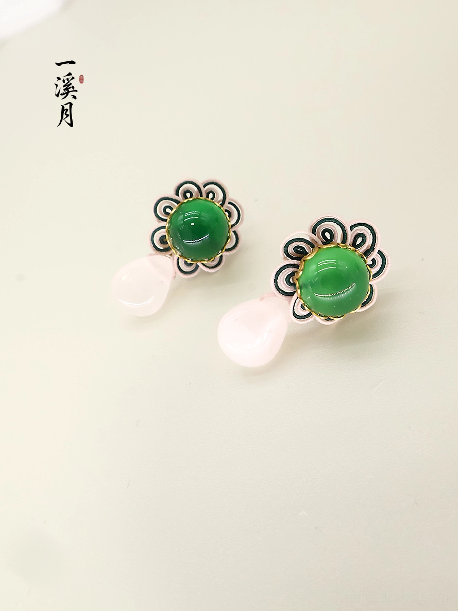 Green chalcedony cabochon flower drop earrings with gold tone trim and translucent pink pendants, flat lay view
