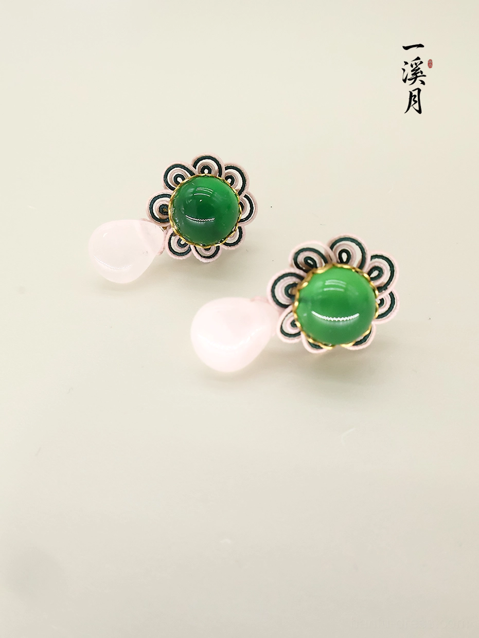 Top view of green chalcedony flower stud earrings featuring ornate dark floral metalwork and pink teardrop dangles