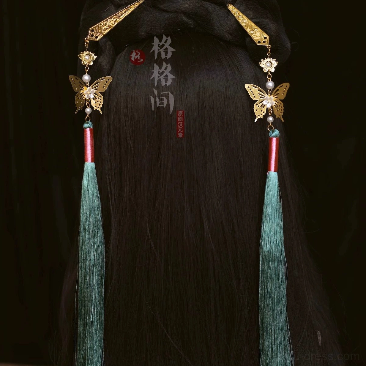 Green Chinese tassel hair pins with gold-tone floral ornaments worn in an elegant traditional Hanfu hairstyle