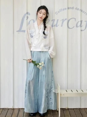 Green Chord Song Dynasty modern Hanfu complete set with white orchid embroidered cross-collar top and light blue wide-leg pants front view