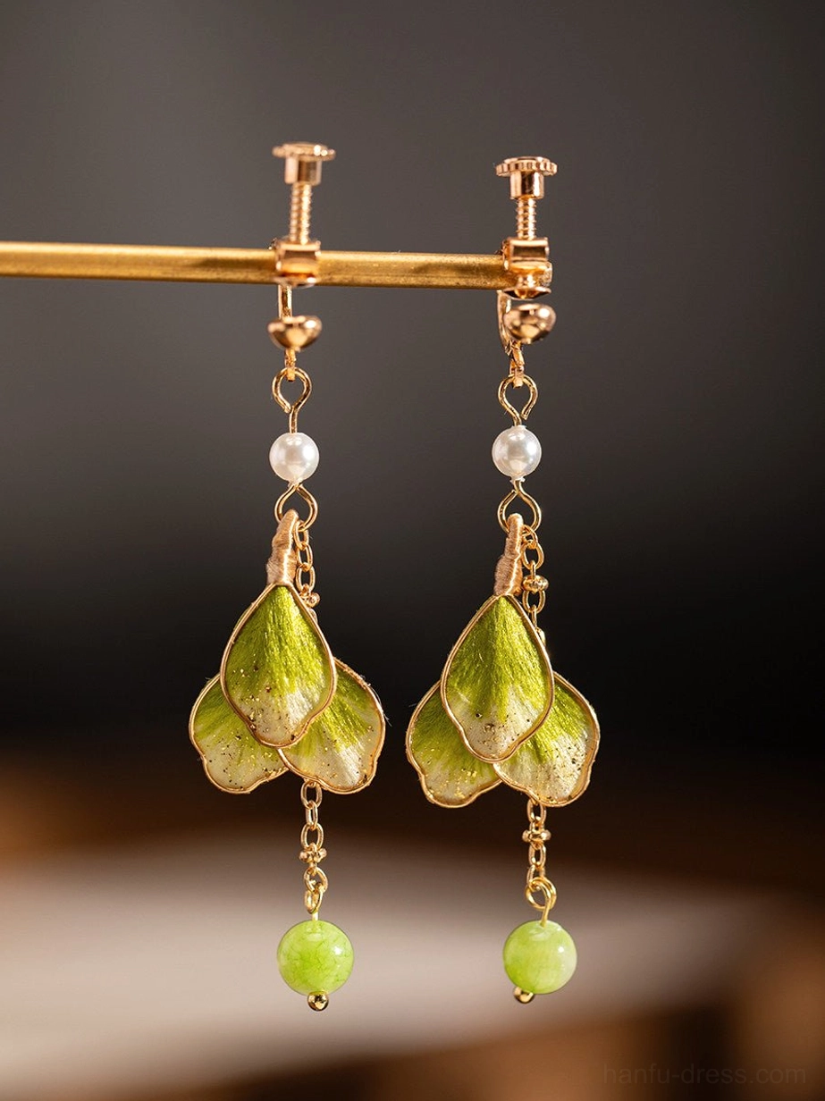 Green flower Hanfu clip-on earrings with gold-tone screw-back clip fittings displayed from the front on a metal stand