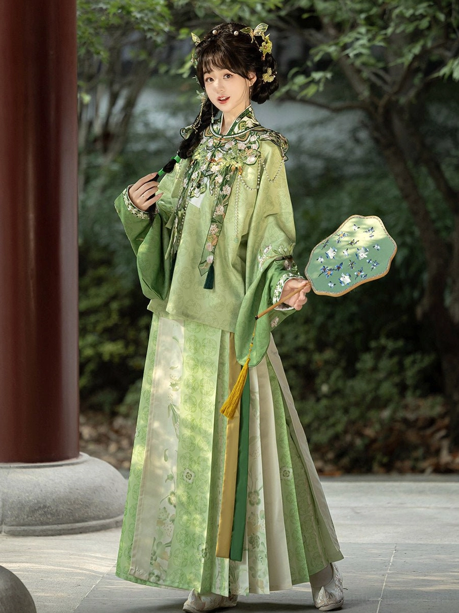 Green Ming Dynasty Hanfu outfit featuring floral embroidered cloud collar, pipa sleeves and color-blocked mamian skirt beside a red wooden pillar