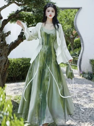 Green modern Hanfu complete set with gradient ink-wash slip dress, off-white tie-front cardigan, bell sleeves, and flowing floor-length skirt in a Chinese garden