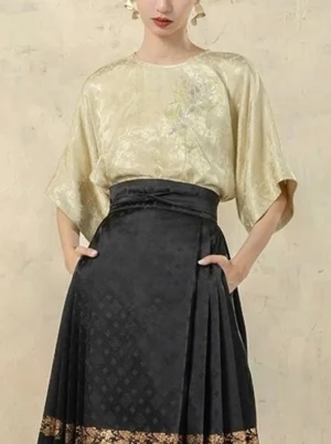 Green satin modern Hanfu top with delicate floral embroidery, textured jacquard fabric, round neck, elbow-length dolman sleeves, and black horse-face skirt