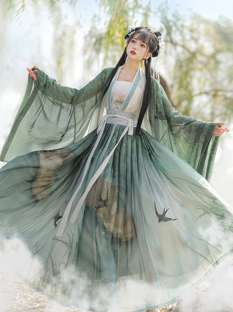 Green Swallow Flight Song Dynasty Hanfu spinning outdoors with flowing wide sleeves, fitted waist, gradient chiffon skirt, flying swallow scenery print, and traditional Chinese styling