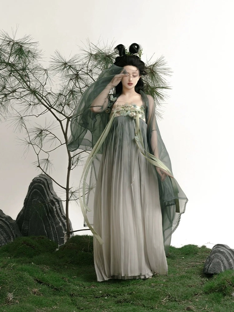 Three-quarter front view of green Tang Dynasty Hanfu dress with loose draped outer robe, full pleated skirt, floral embroidery, and matching decorative sash pendant