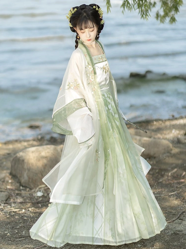 Rear side view of green and white Song Dynasty Hanfu showing asymmetrical layered beizi hem and floral embroidery