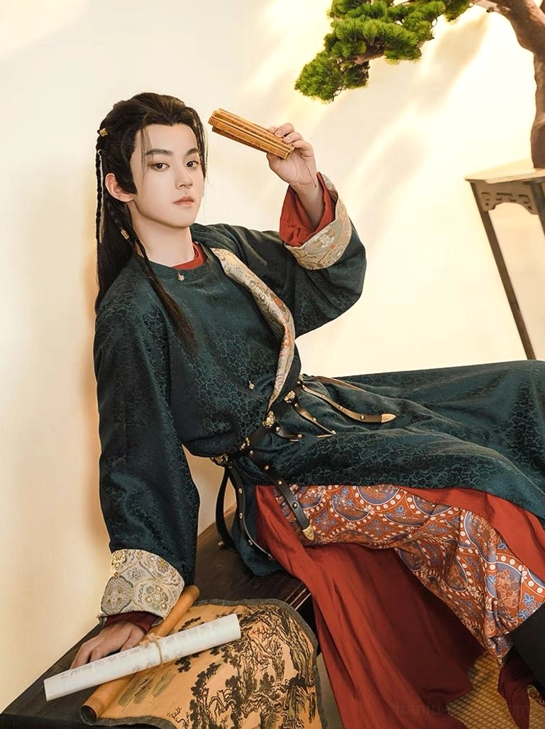 Guan Shan Yue Tang-style male Hanfu side view with red inner robe layer, long dark teal round-collar outer robe, embroidered cuffs, and bamboo slips