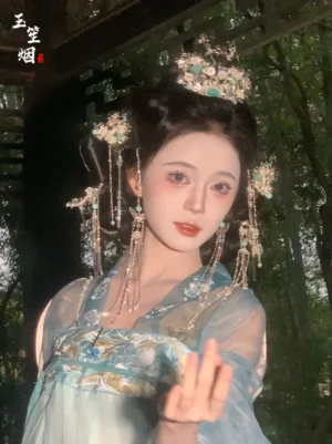 Close view of the double phoenix crown with turquoise-toned stones pearls and matching tassel hairpins worn with a cyan Hanfu outfit at night