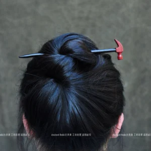 Hammer-shaped Chinese hair stick worn through a traditional topknot, shown from the back against a dark gray background