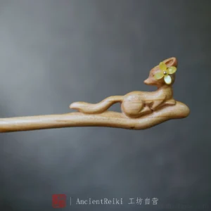 Close-up of a hand-carved wooden fox Chinese hair stick with a yellow four-petal flower detail and natural wood grain for Hanfu hairstyles