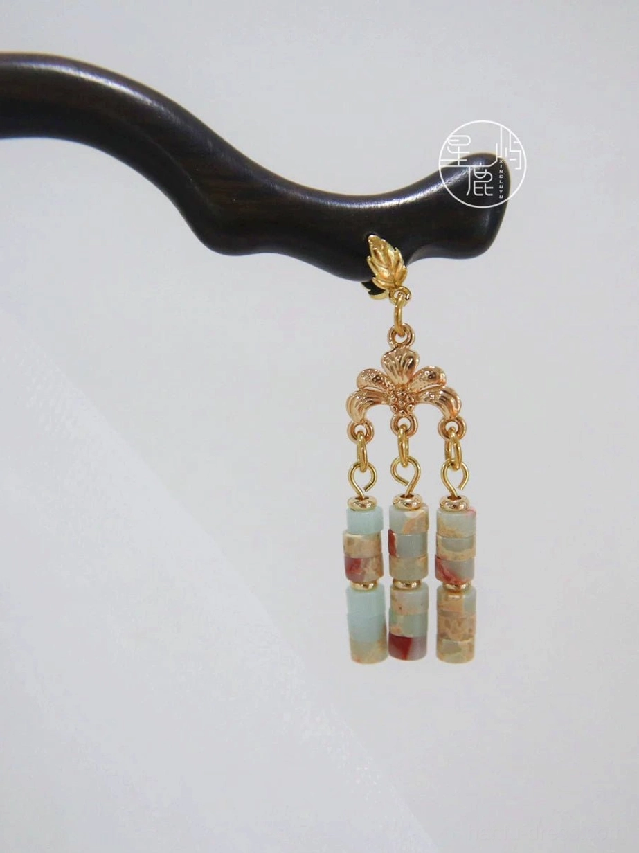 Handmade Chinese hair stick with gold leaf-inspired ornament and three matching marbled stone tassel beads on a white background