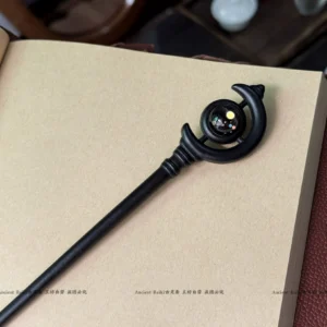 Handmade traditional Chinese hair stick with twisted decorative joint, crescent ornament, and colorful bead photographed with leather and tea ware