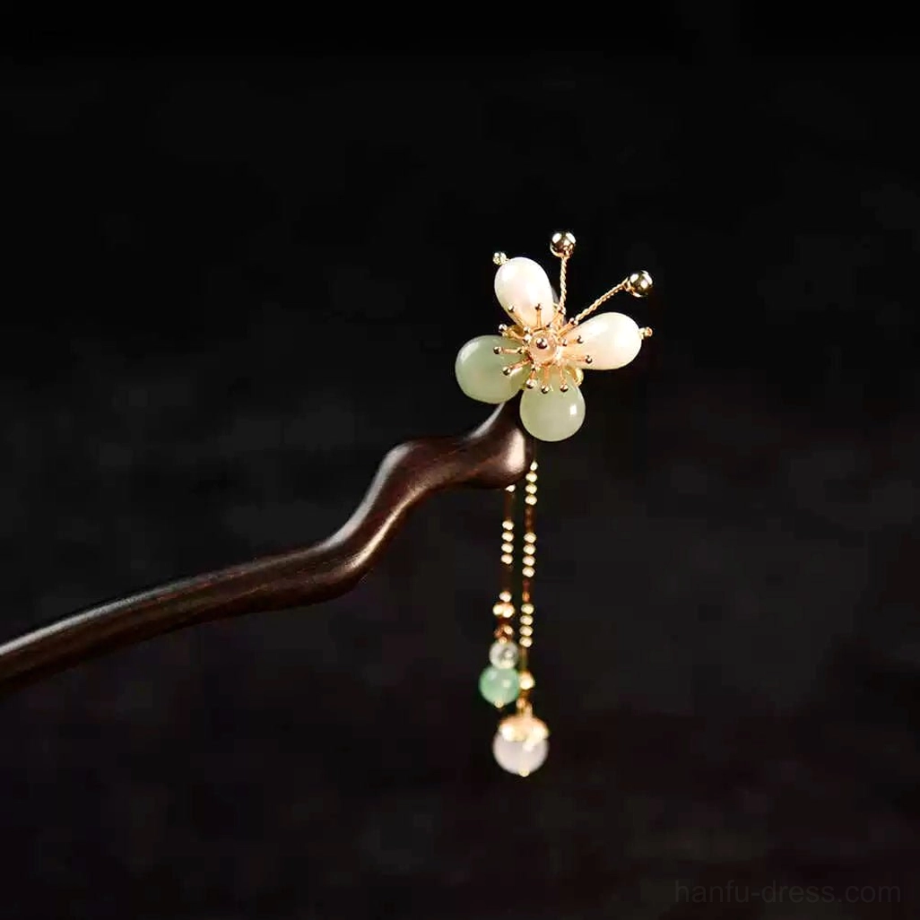 Full view of a handmade Chinese plum blossom hair stick featuring a curved wooden pin, floral ornament, gold-toned details, and elegant dangling tassel