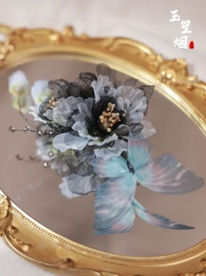 Handmade Chinese Hanfu hair accessory with translucent blue butterfly, charcoal gray fabric flowers, metallic beads, and decorative branch details