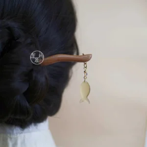 Handmade Hanfu wooden hairpin with dangling fish charm shown in a braided low bun hairstyle from the back
