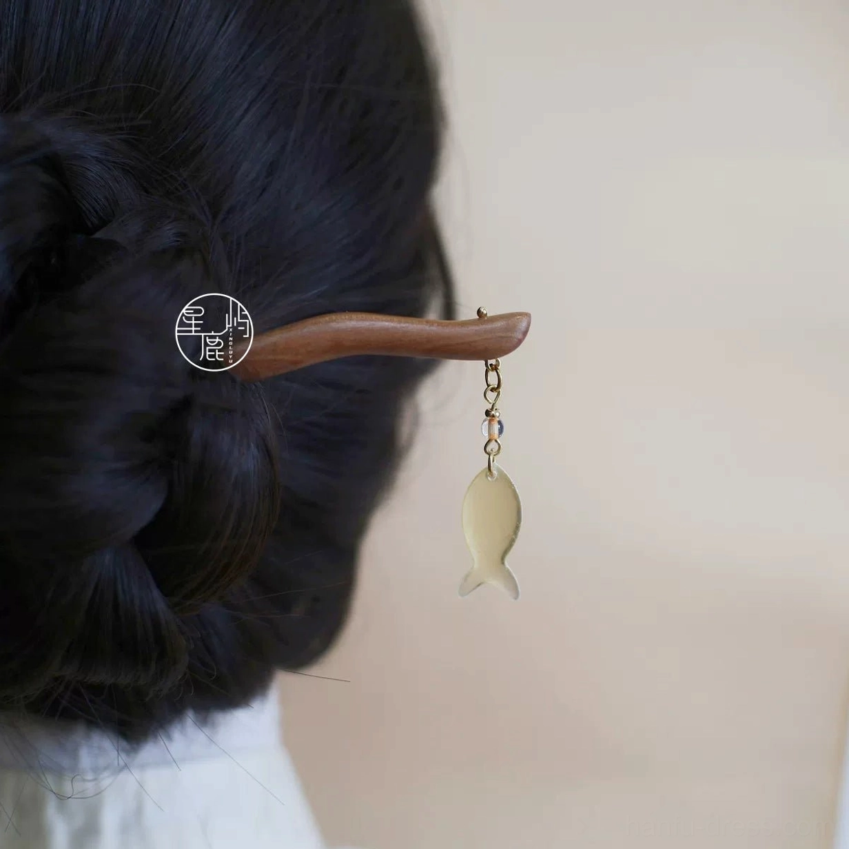 Handmade Hanfu wooden hairpin with dangling fish charm shown in a braided low bun hairstyle from the back