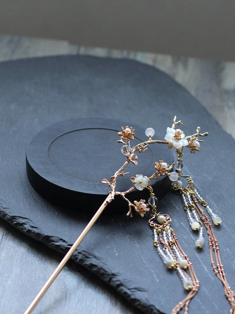 Front close-up of handmade pear blossom Hanfu hair stick highlighting gold-tone floral branch, white blossoms, bead accents, and tassel hardware