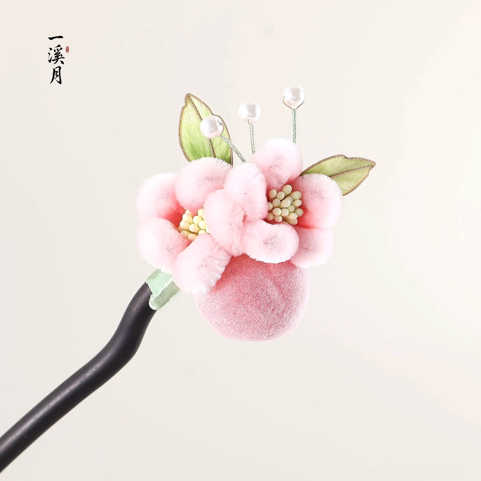 Handmade puffy bloom Chinese hair stick with pink plush flower green foliage and pearl accents on a neutral background