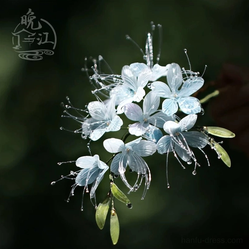 Handmade traditional Chinese flower hair accessory featuring a compact cluster of translucent blue petals green leaves and water drop wire ornaments