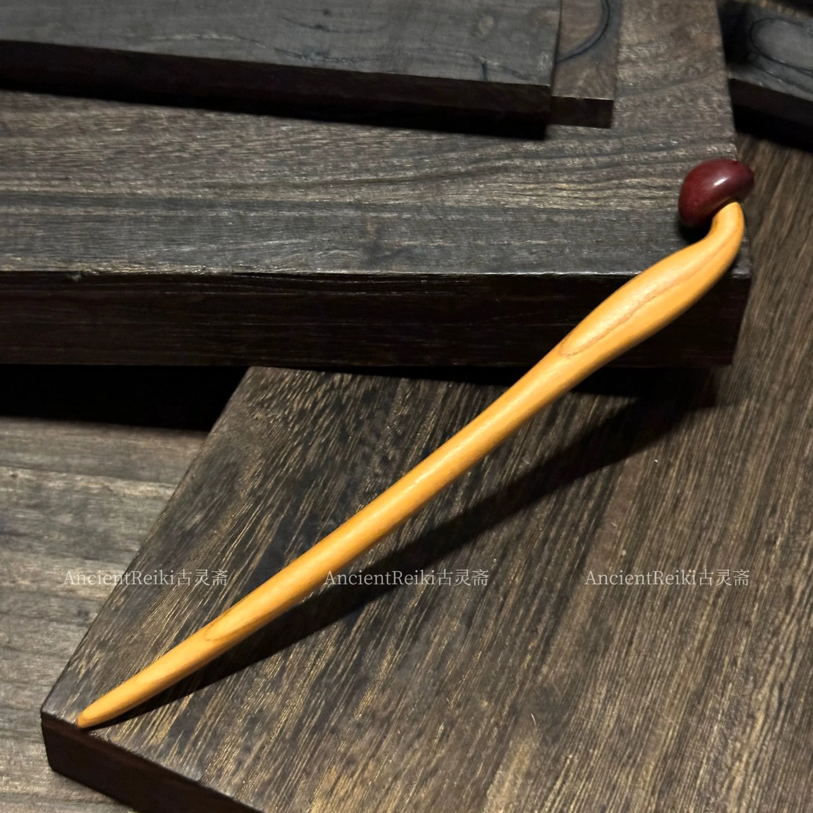 Handmade wooden mushroom Chinese hair stick with a light polished wood shaft and dark reddish-brown mushroom-shaped top displayed on a dark wooden table