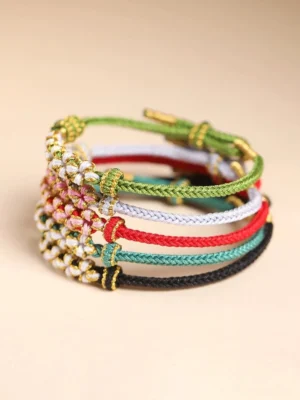 Stacked handwoven Chinese knot flower bracelets in green white red teal and black color options with gold-tone details